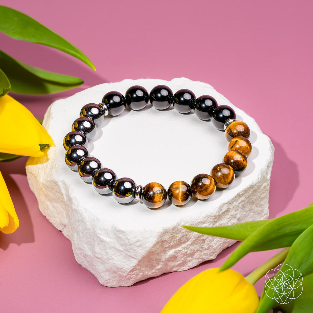 Beaded bracelet on a white stone with yellow tulips on a pink background