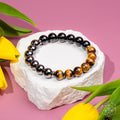 Beaded bracelet on a white stone with yellow tulips on a pink background