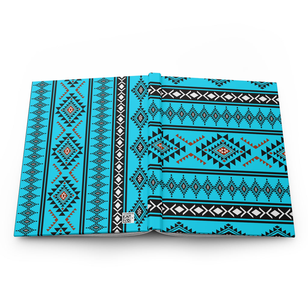 An open book or magazine showing a bright turquoise, black, and white geometric tribal pattern on the pages, photographed against a clean white background.