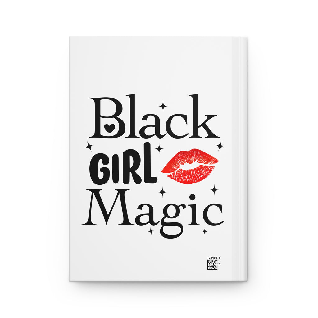 A white hardcover notebook featuring the text 'Black Girl Magic' in black lettering with a red lipstick kiss mark and small black star accents on the cover.