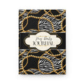 A hardcover daily journal with a black and white zebra print cover patterned with gold chains and pearl-like circles, featuring a cream-colored central label with the text 'My Daily JOURNAL'.