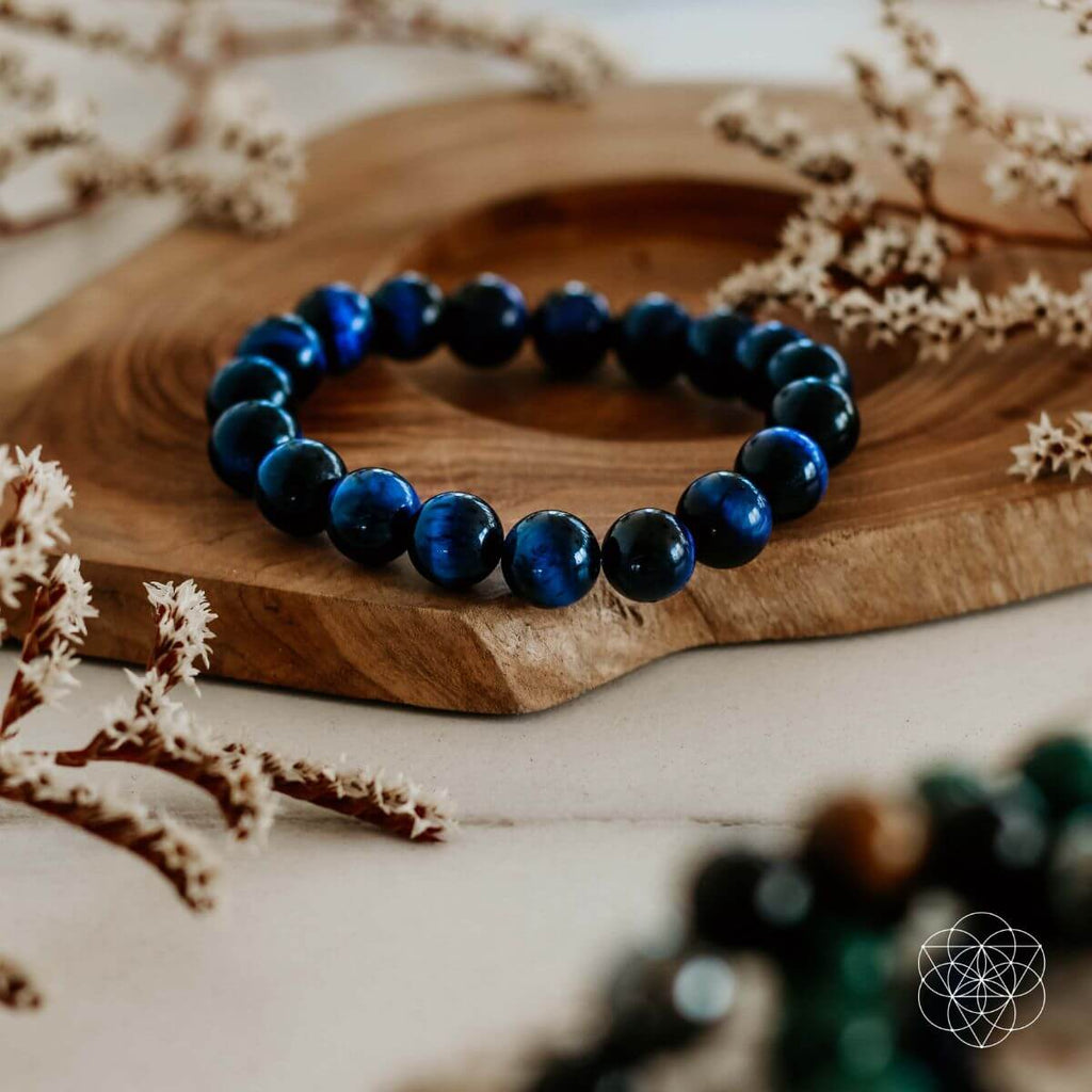Blue beaded bracelet on a wooden surface with dried plants
