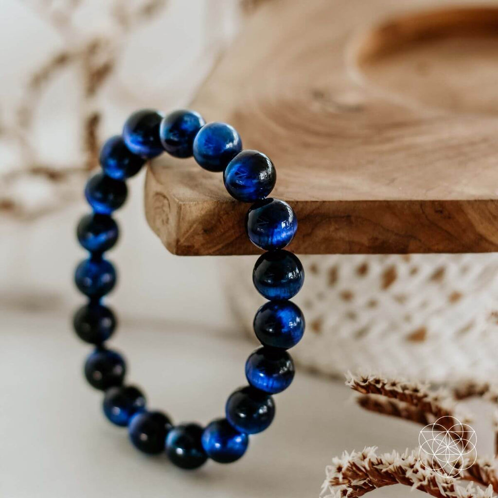 Blue beaded bracelet on a wooden surface with a natural background