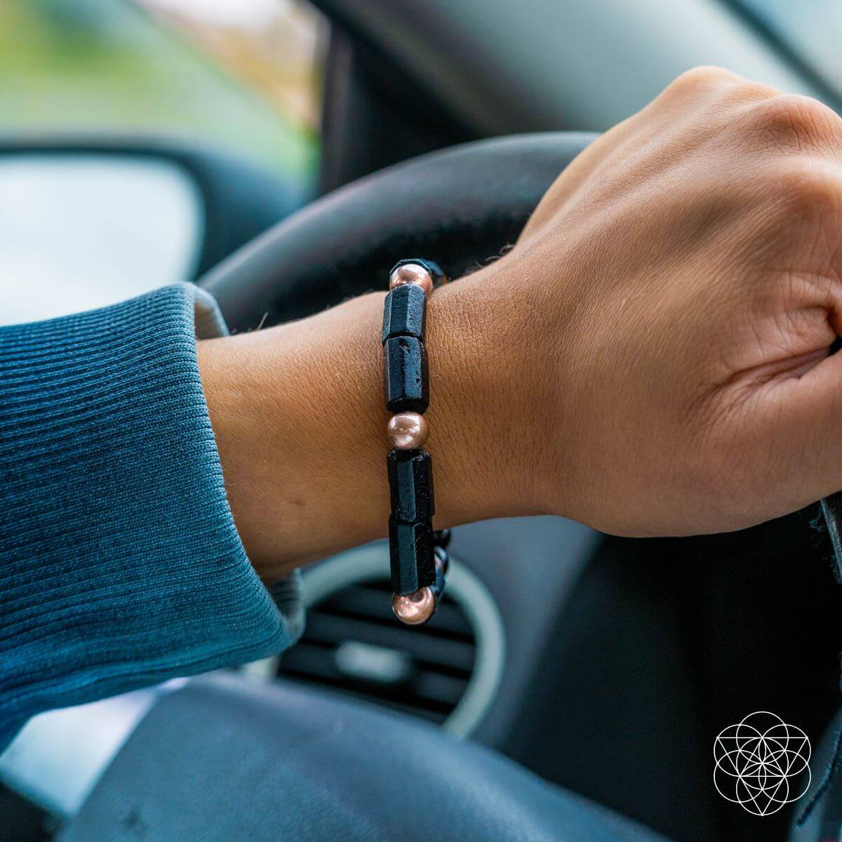 Person driving a car with a bracelet on wrist