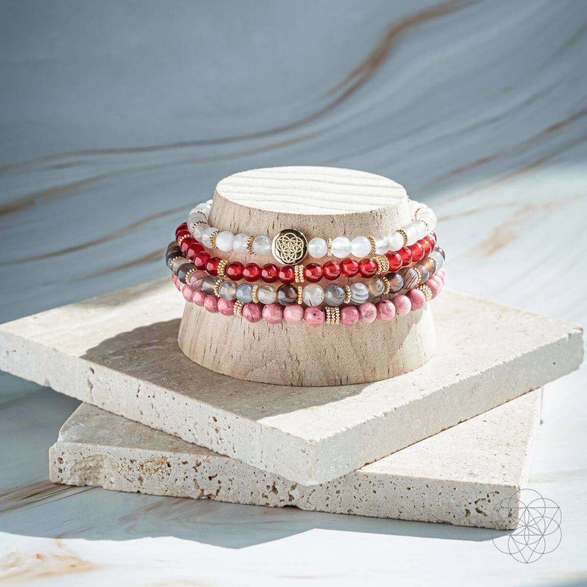 Stack of beaded bracelets on a wooden block with a neutral background