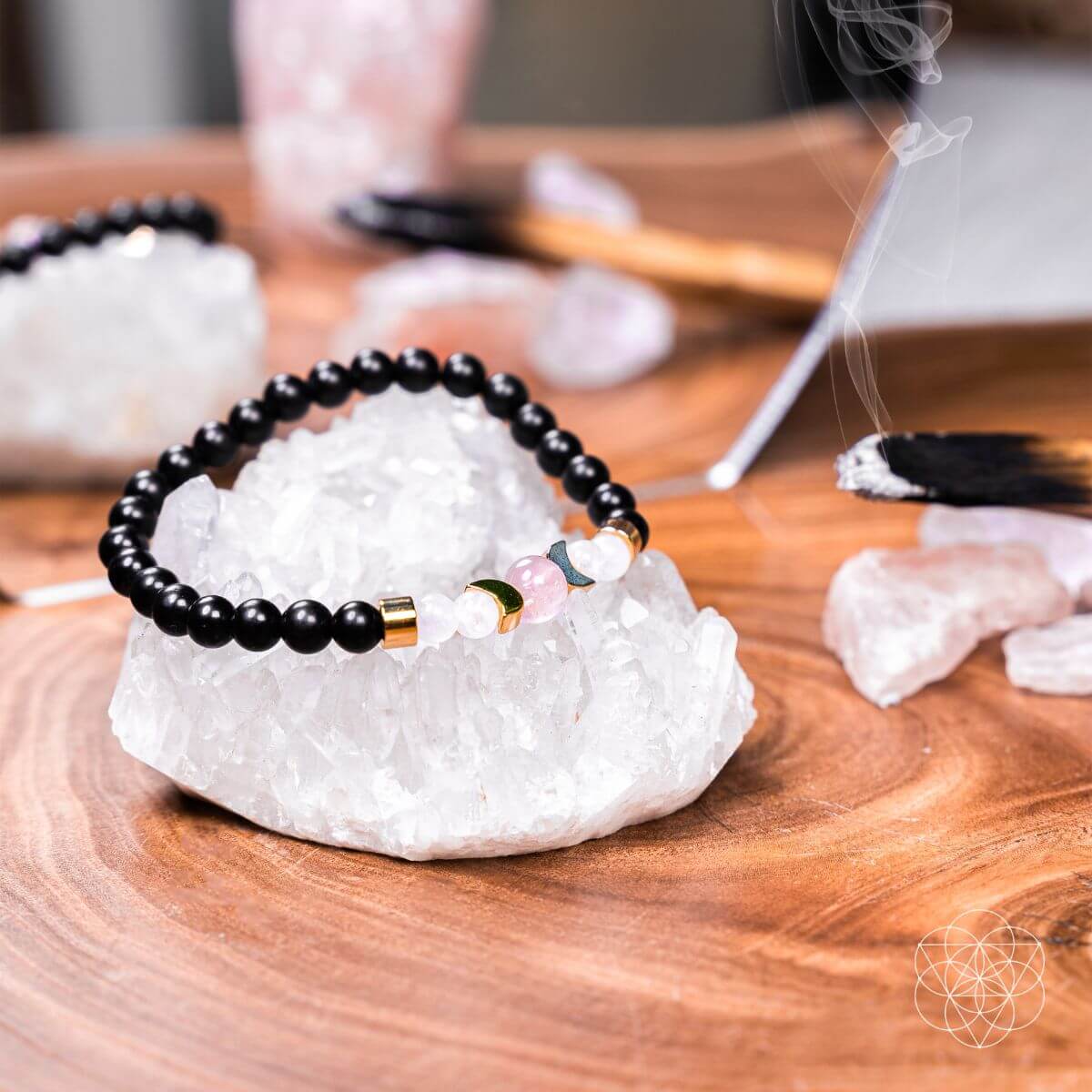 Black beaded bracelet with colorful accents on a white crystal on a wooden surface.