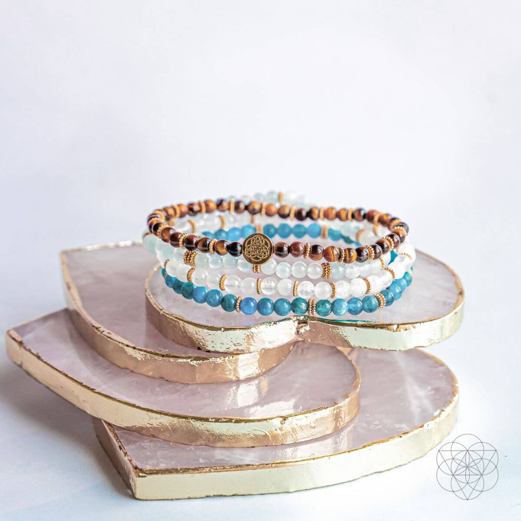 Stack of bracelets on a decorative tray with a white background