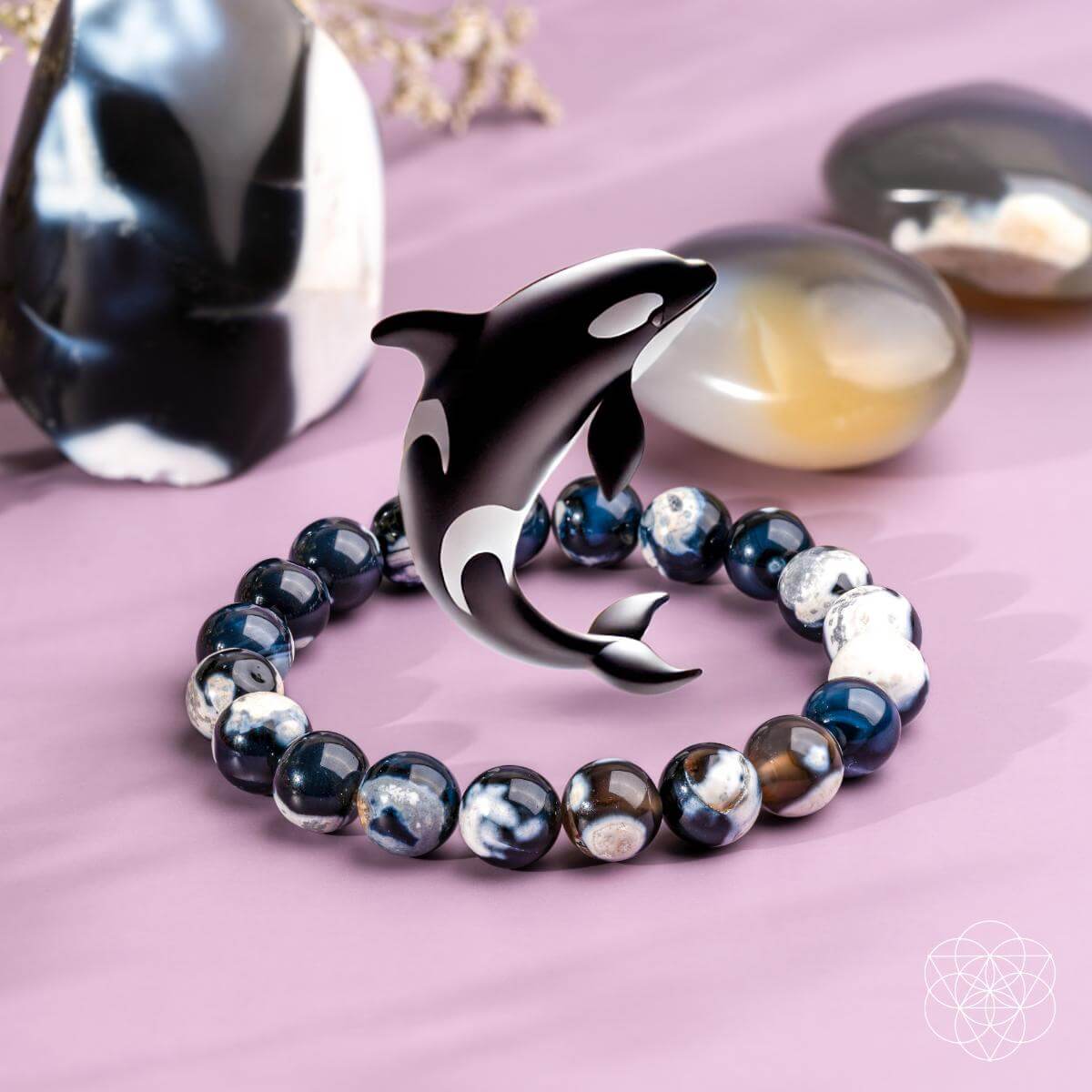 Bracelet with a dolphin charm on a pink surface