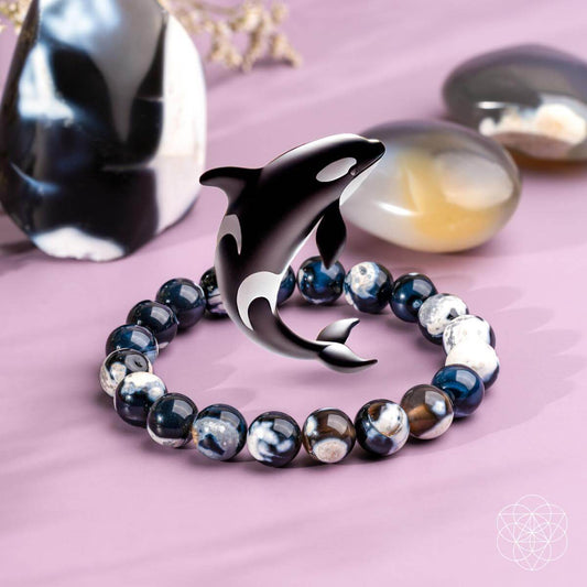 Bracelet with a dolphin charm on a pink surface