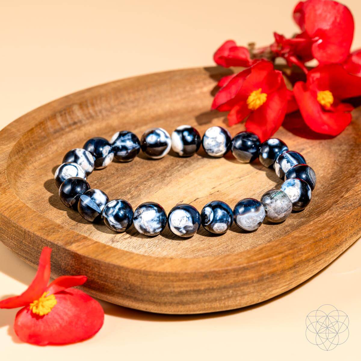 Beaded bracelet on a wooden plate with red flowers