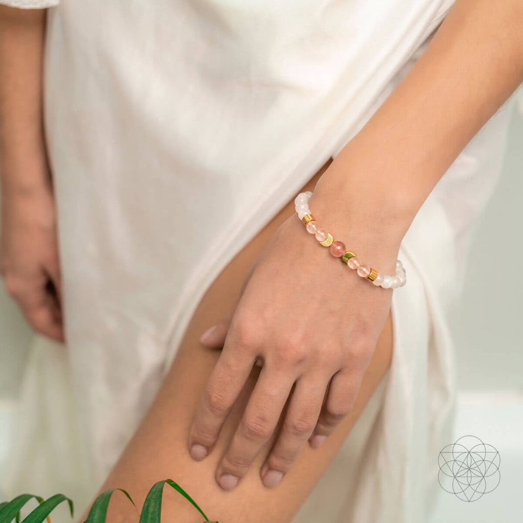 Close-up of a hand wearing a beaded bracelet with a blurred background