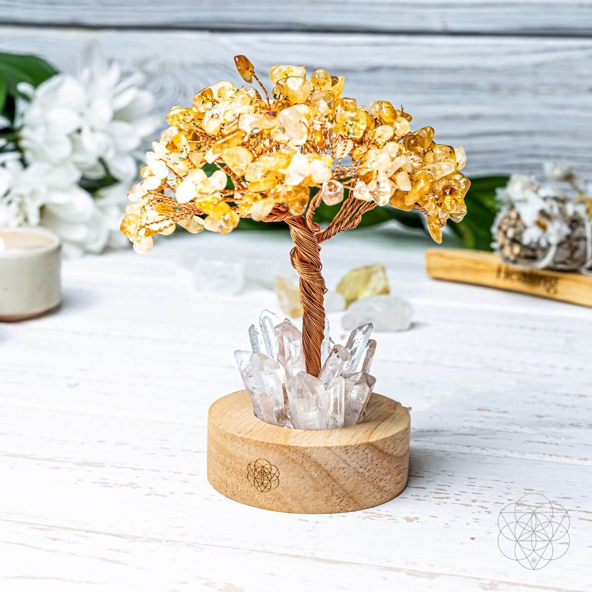 Decorative crystal tree with yellow beads on a wooden base, set against a light background.