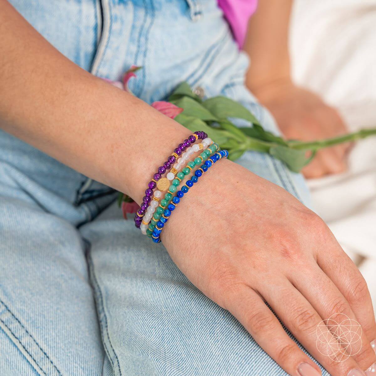 Close-up of a person's wrist wearing colorful beaded bracelets with a blurred background.