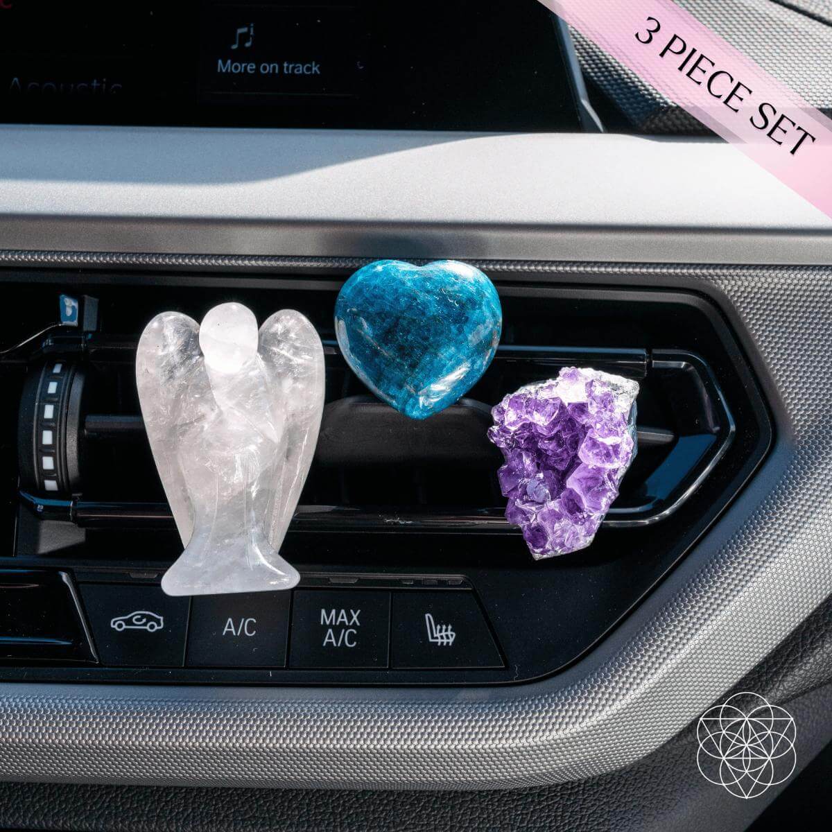 Three crystal car air fresheners in angel, heart, and amethyst shapes on a car vent.