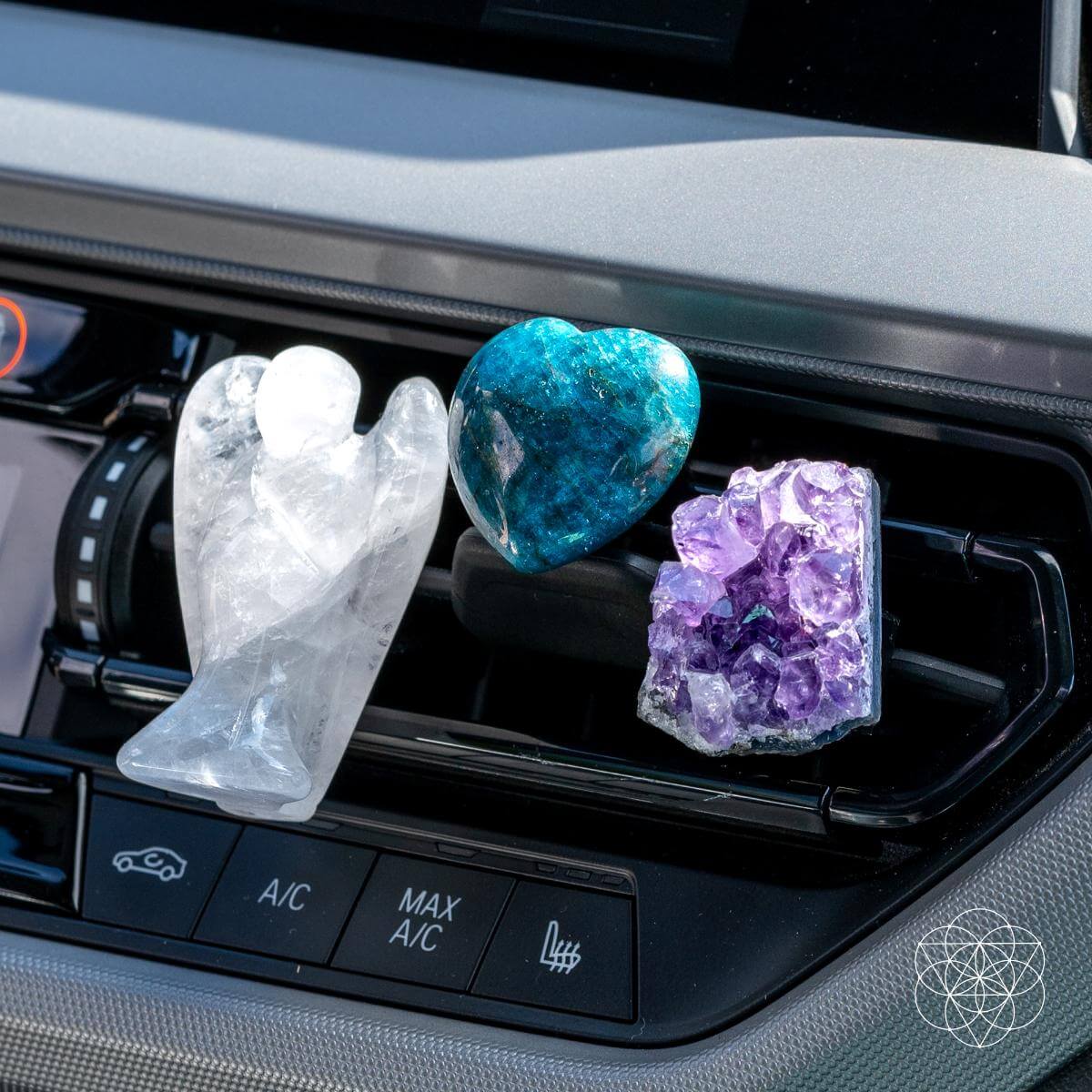 Decorative crystal angel figurines on a car air vent.