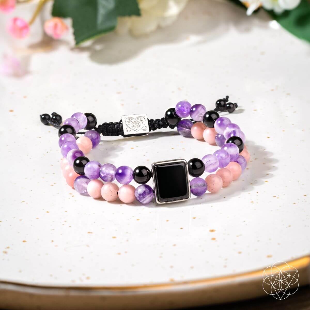 Multicolored beaded bracelet on a white plate with a blurred floral background