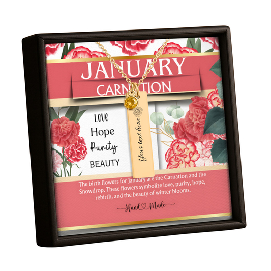 A framed January Carnation personalized keepsake box necklace. The gold necklace with a round gold charm and a beige tag reading 'Yours love here' is displayed inside a black square frame over a decorative card with red carnation illustrations and text.