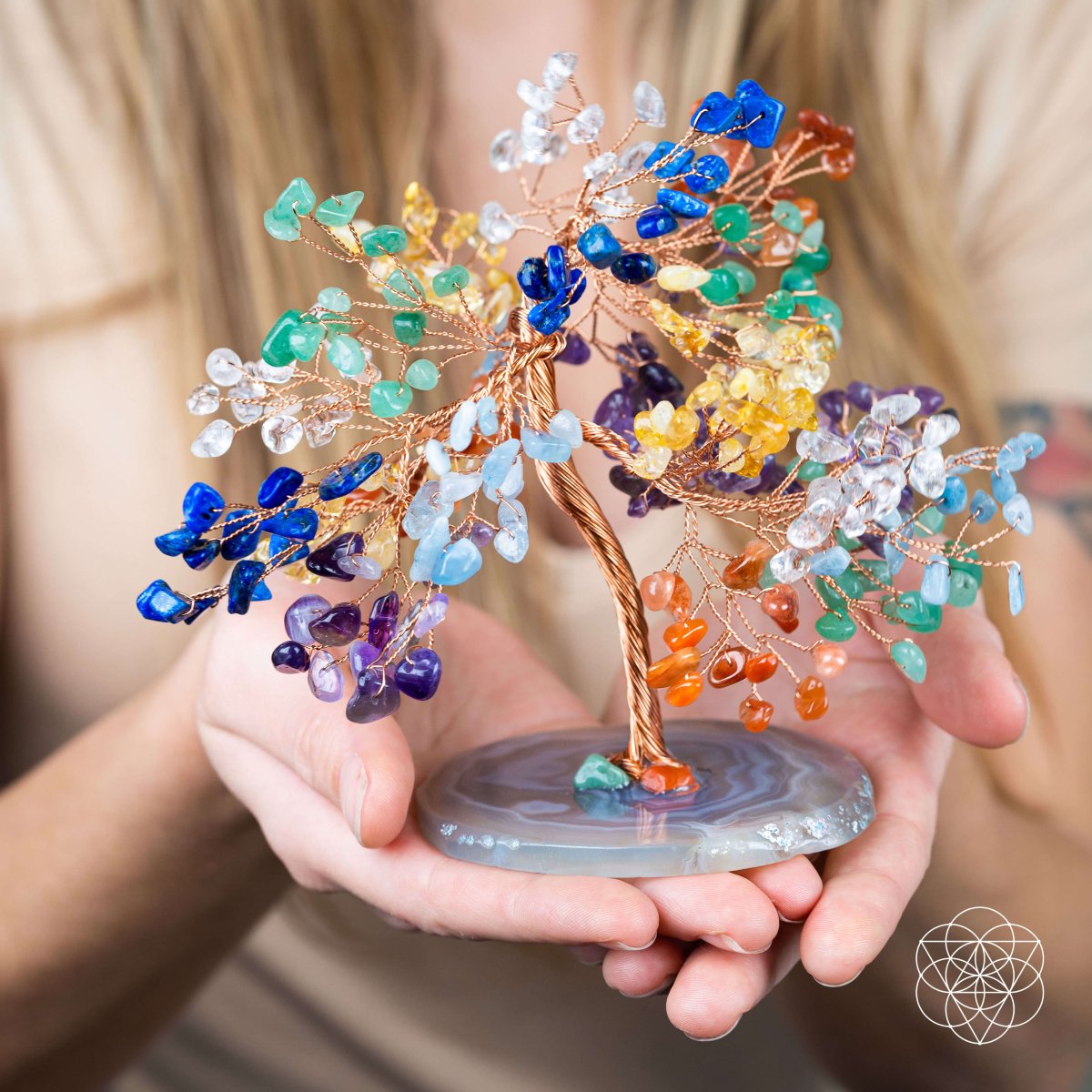 Colorful crystal tree held by hands with a blurred background