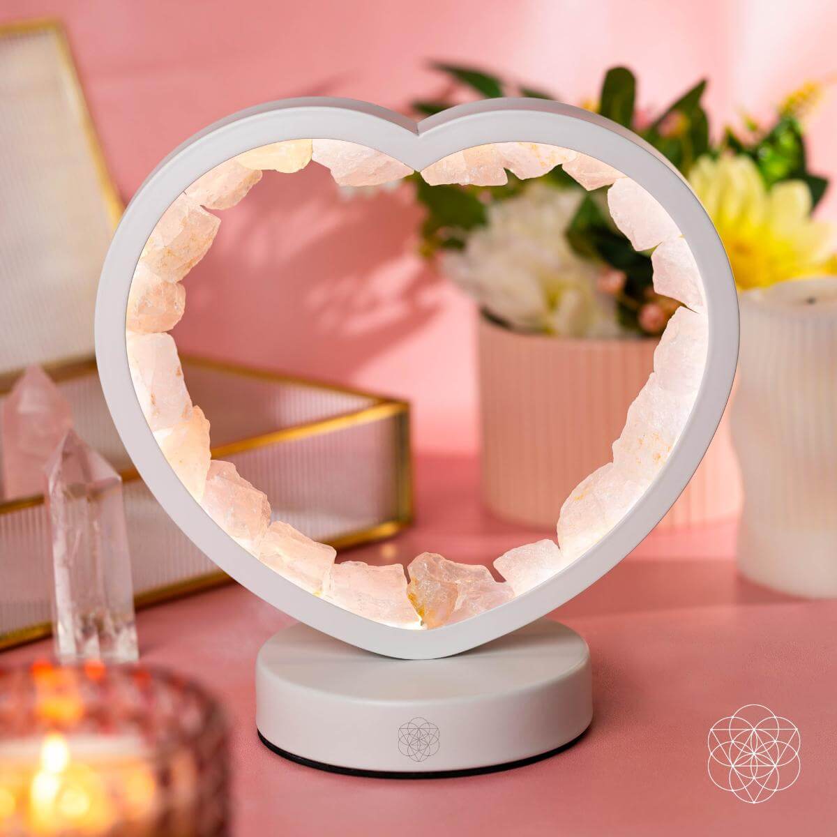 Heart-shaped lamp on a pink surface with decorative items in the background