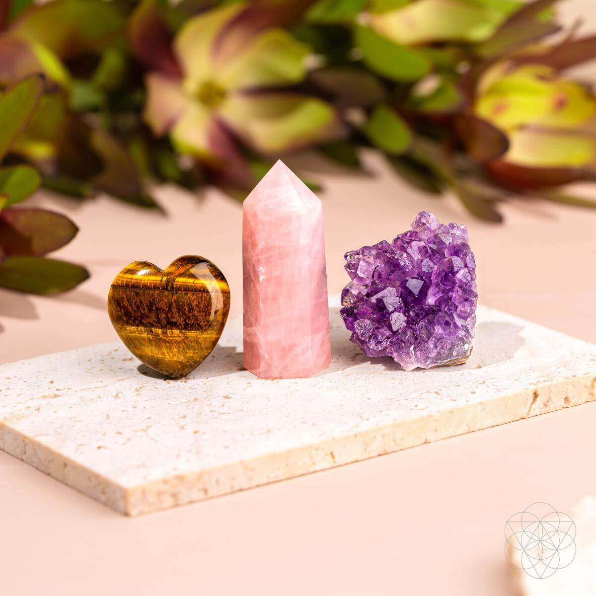Three crystals on a white stone surface with a blurred natural background