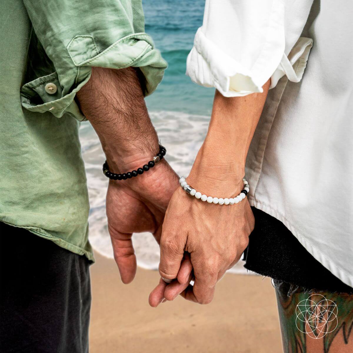 Two people holding hands on a beach with a blurred background