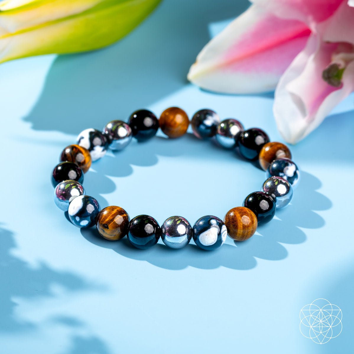 Beaded bracelet with multicolored stones on a blue surface with flowers in the background