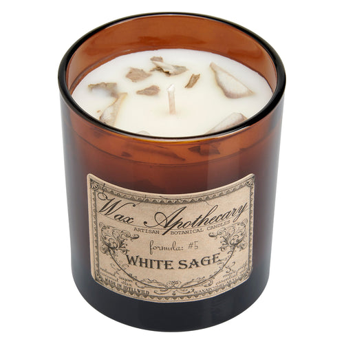 Candle in an amber glass jar with a label on a white background