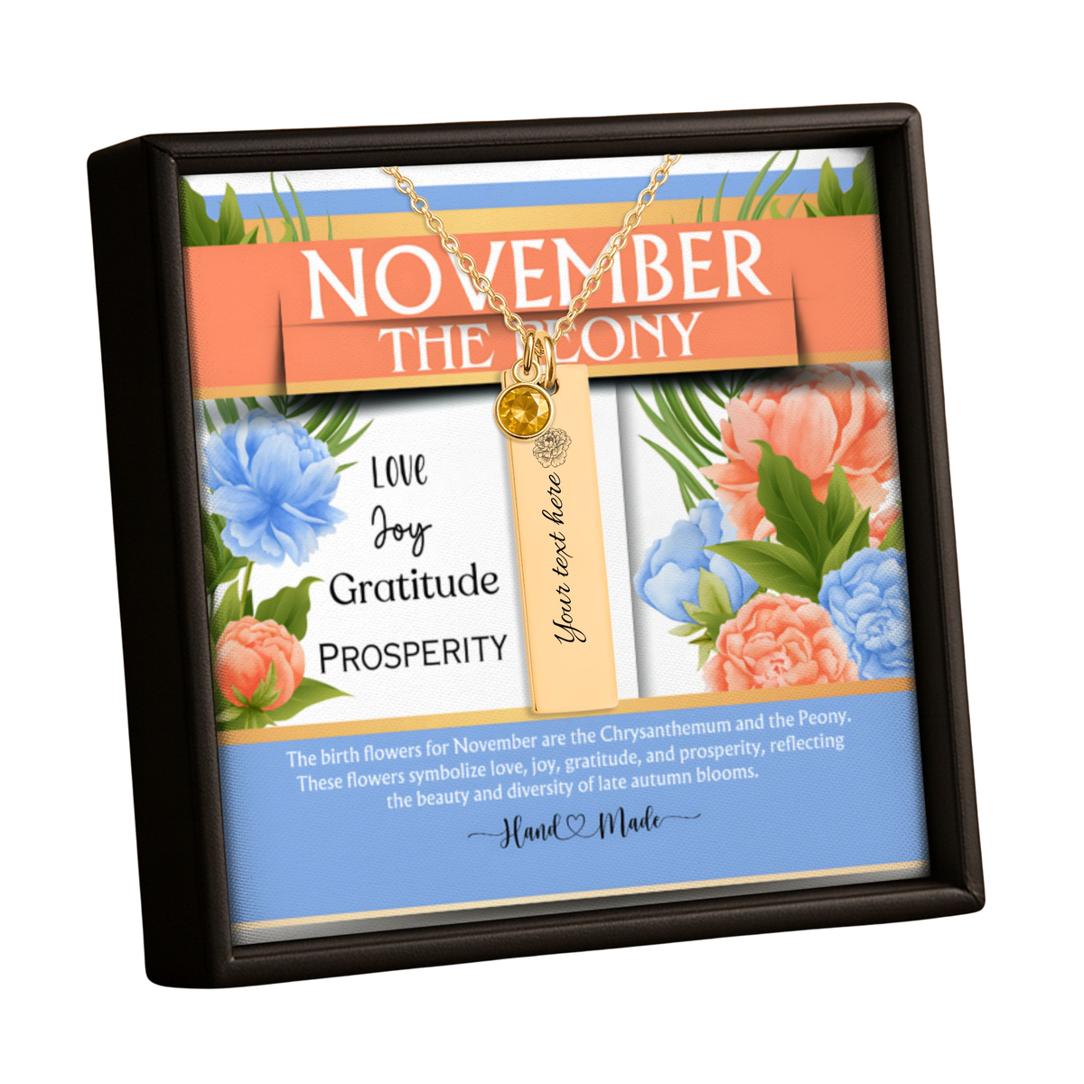 A framed November the 3rd gratitude necklace gift set. The set includes a gold chain necklace with a round gold bead and a vertical gold tag that reads 'love joy gratitude prosperity' and 'Your love here'.