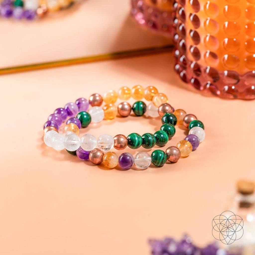 Multicolored beaded bracelet on a light pink surface with a blurred background