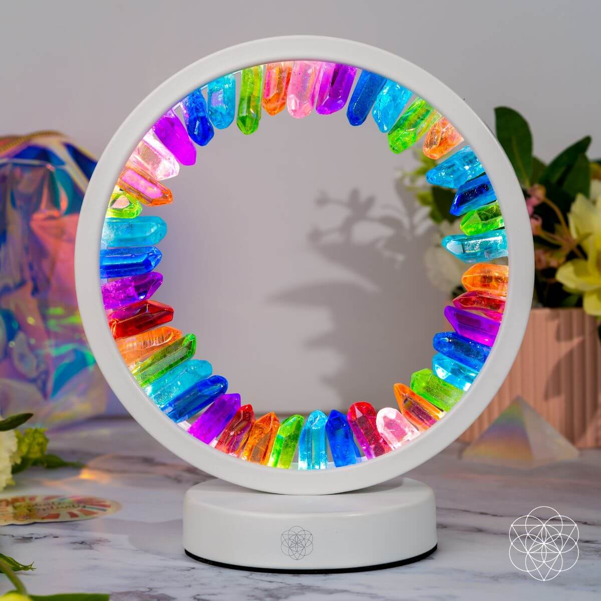 Colorful circular light fixture on a white base with a blurred background