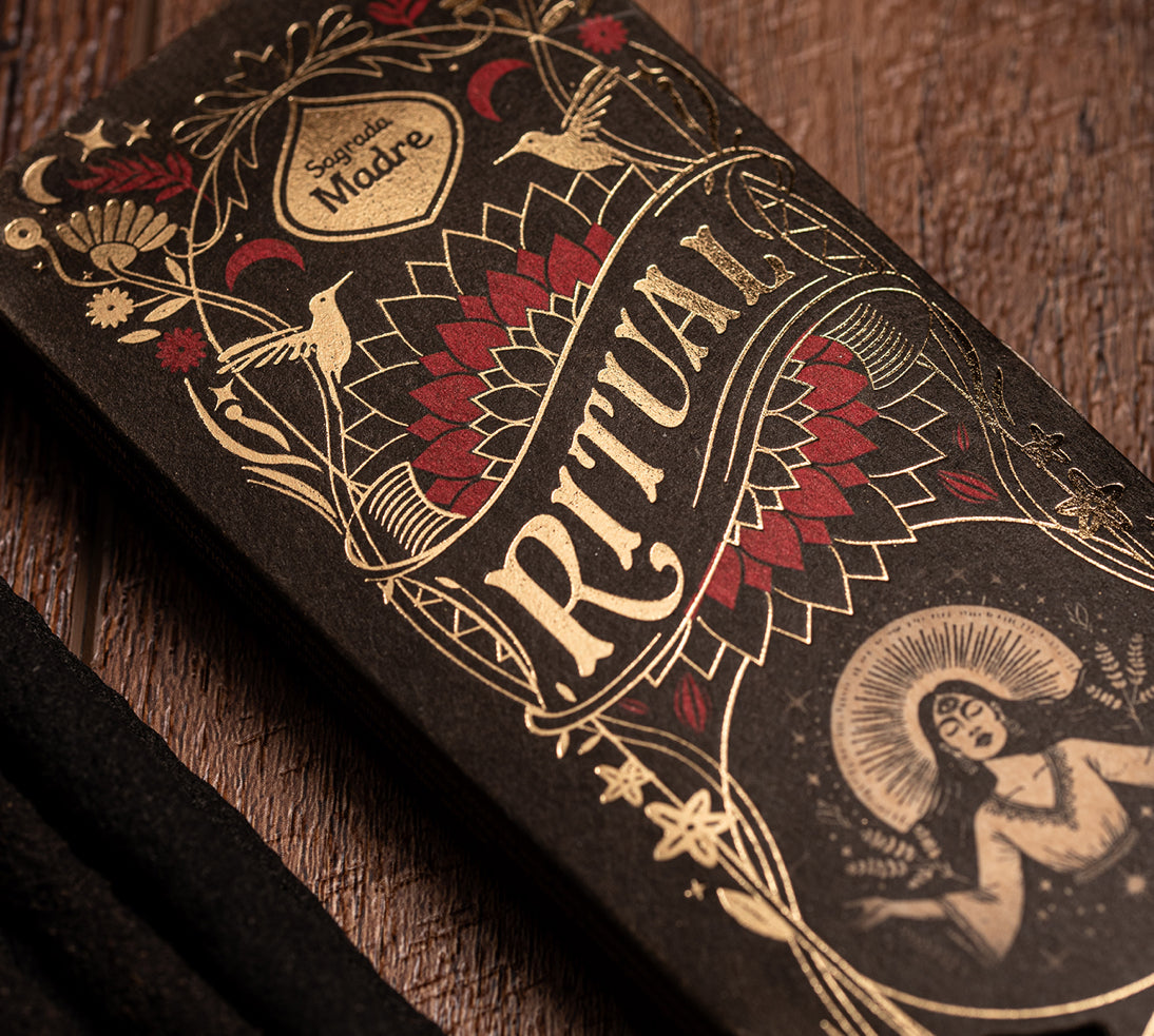 Decorative packaging with 'Ritual' text and intricate designs on a wooden surface
