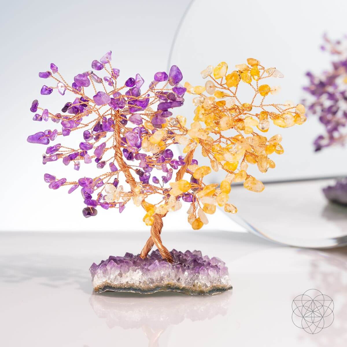 Crystal tree sculpture with purple and yellow crystals on a white background