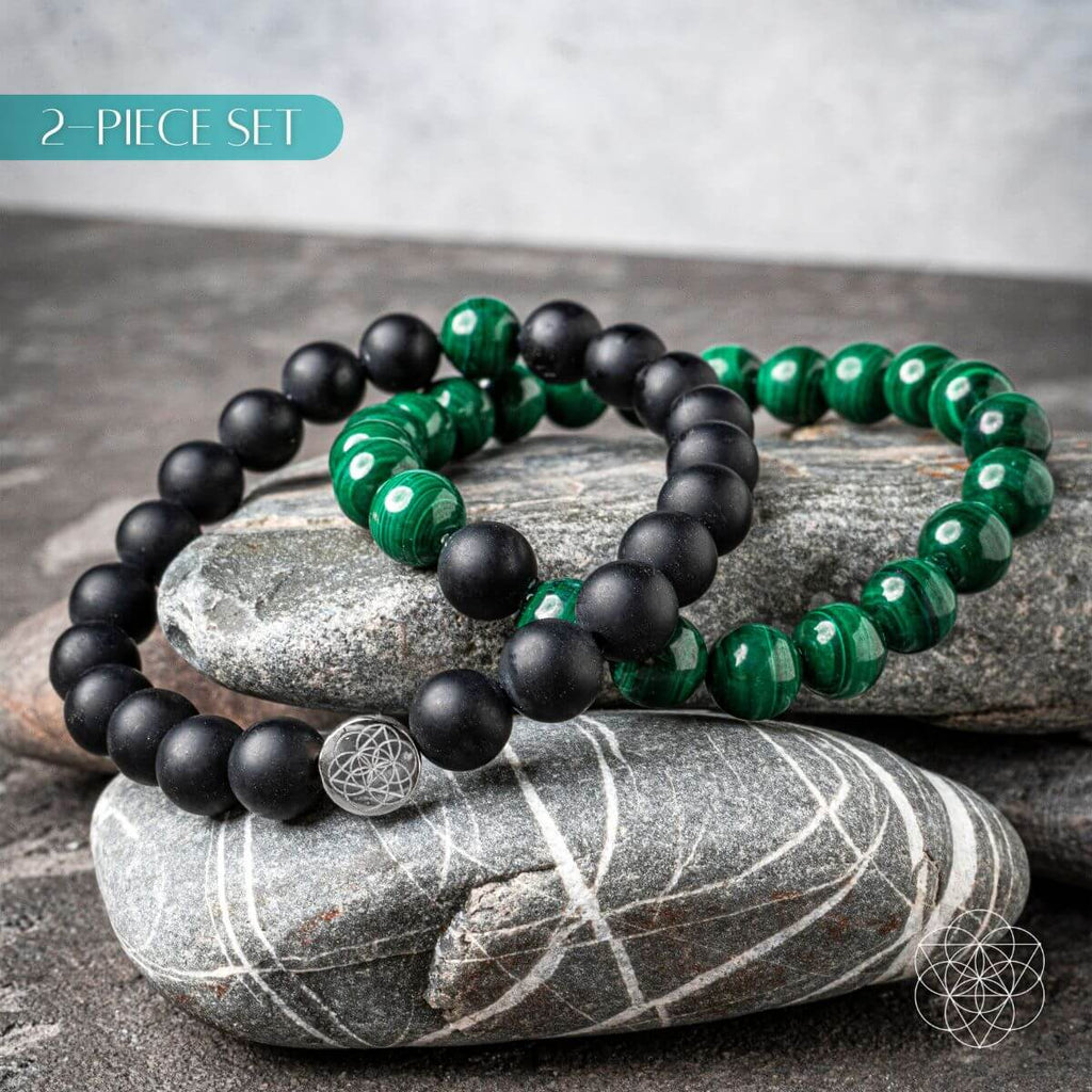Two black and green beaded bracelets on a stone surface with '2-Piece Set' text.
