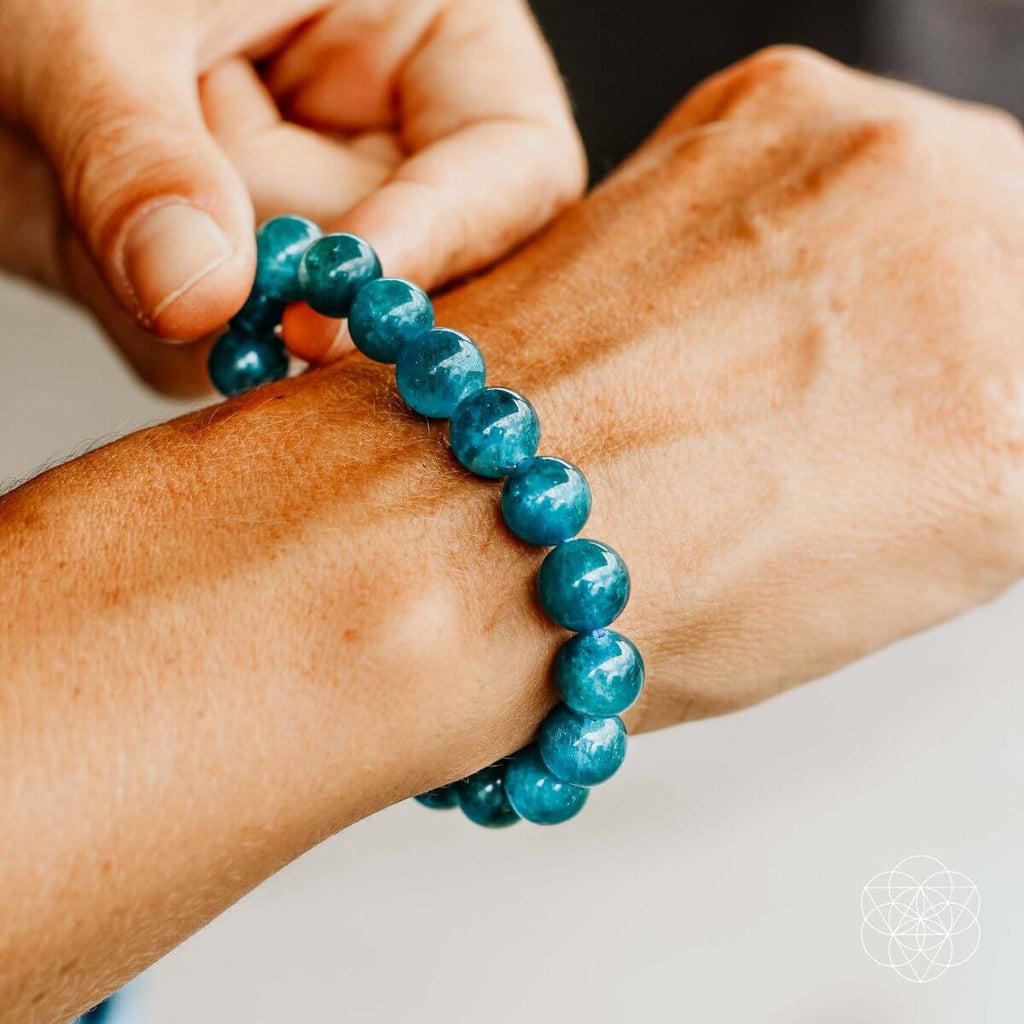 Person wearing a blue beaded bracelet on their wrist