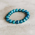 Turquoise beaded bracelet on a textured beige surface