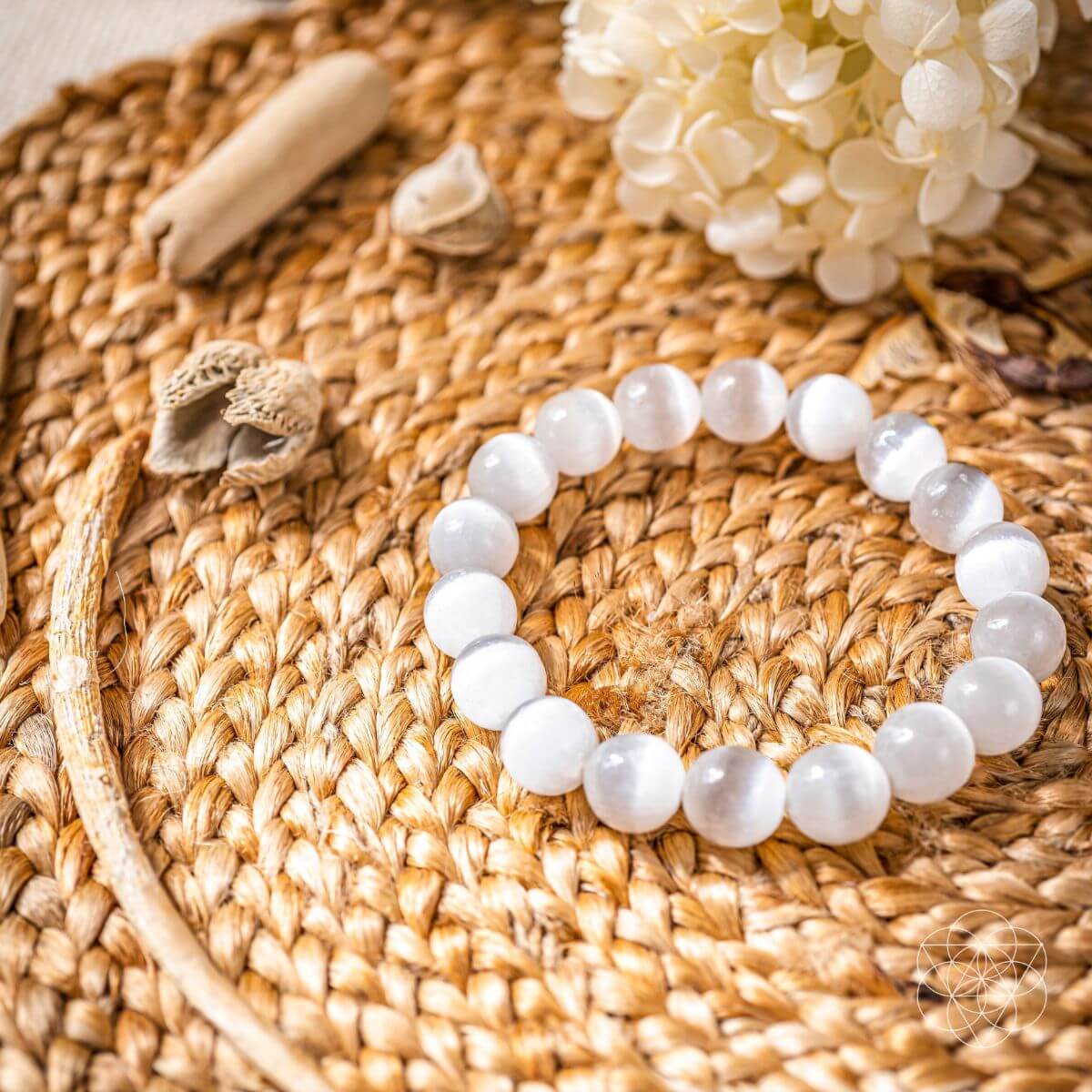 White beaded bracelet on a woven surface with decorative elements
