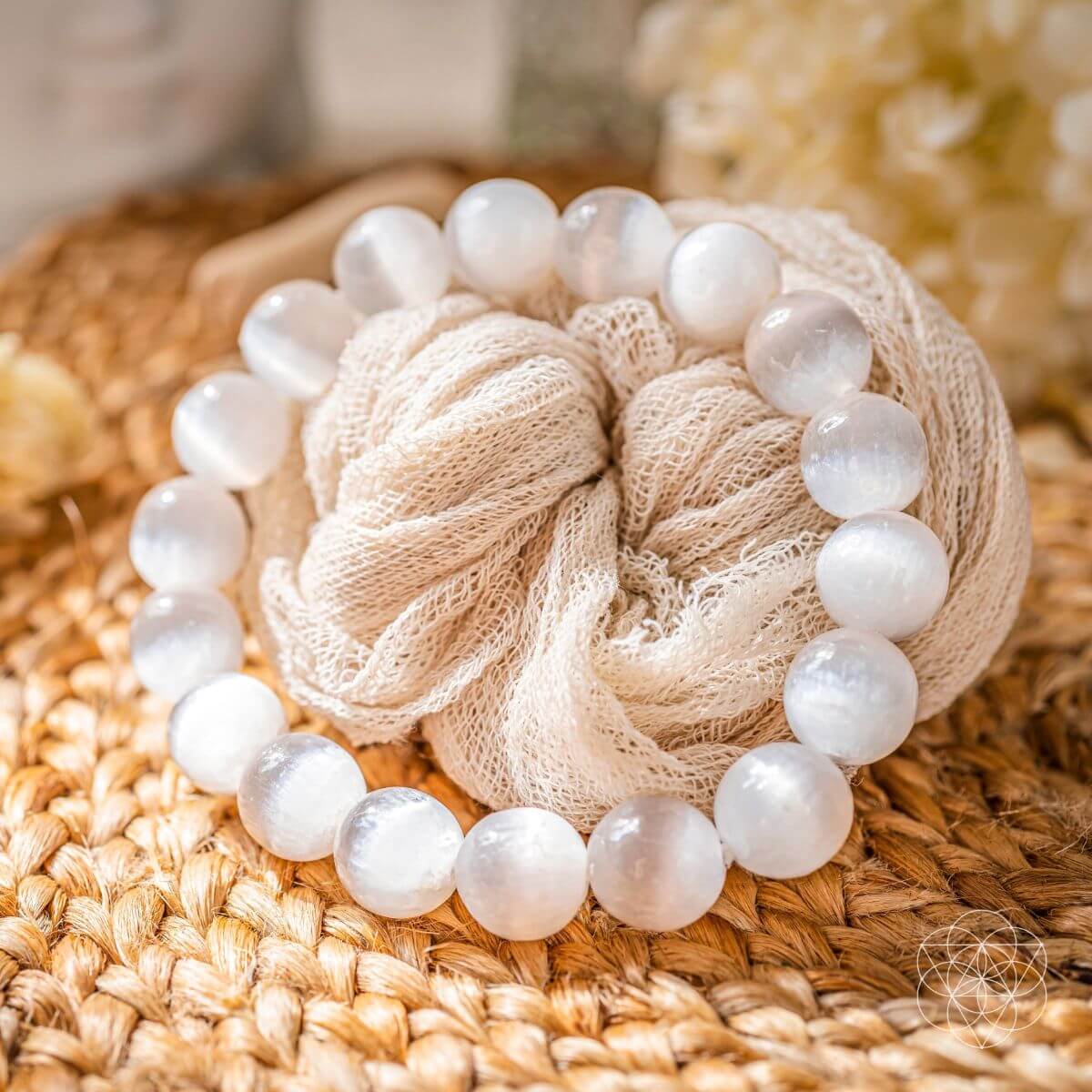 White beaded bracelet with a knotted design on a woven surface