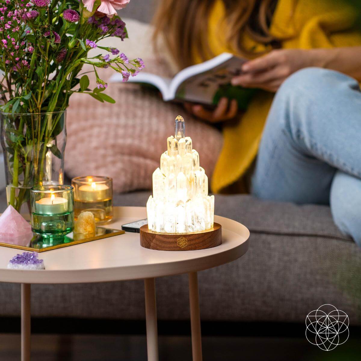 Decorative crystal lamp on a coffee table with candles and flowers in the background