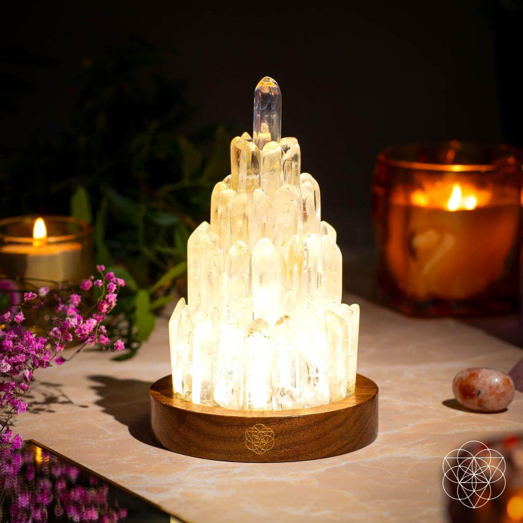 Crystal lamp with wooden base on a table with candles and flowers in the background
