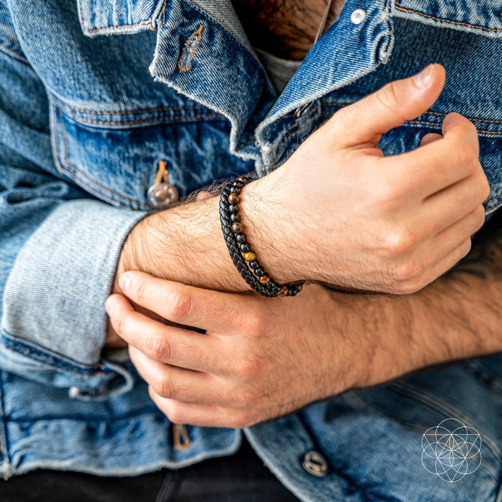 Close-up of a person wearing a blue denim jacket with a bracelet on their wrist.