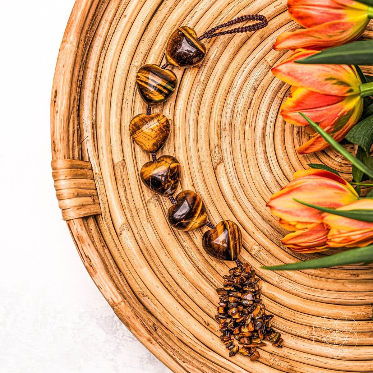 Wooden bracelet with tiger eye stones on a woven mat with tulips
