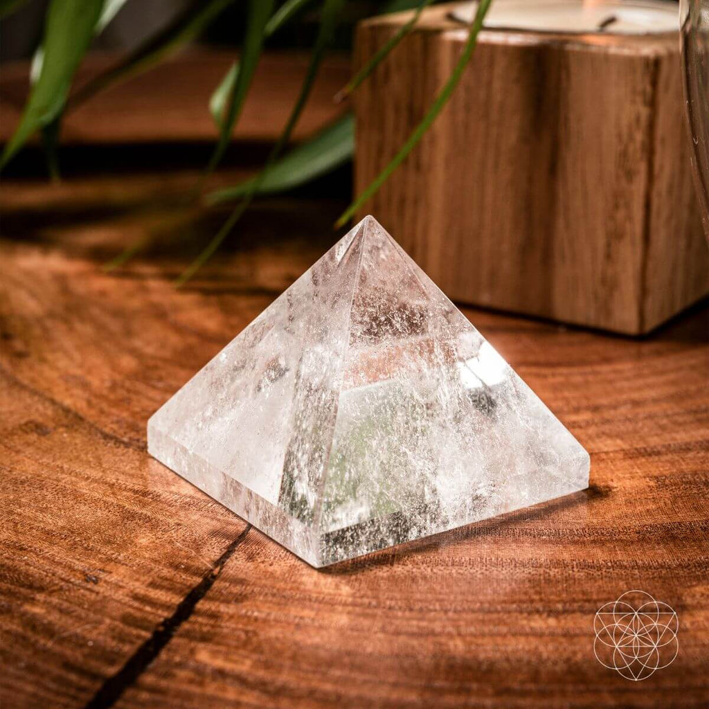 Crystal pyramid on a wooden surface with a natural background