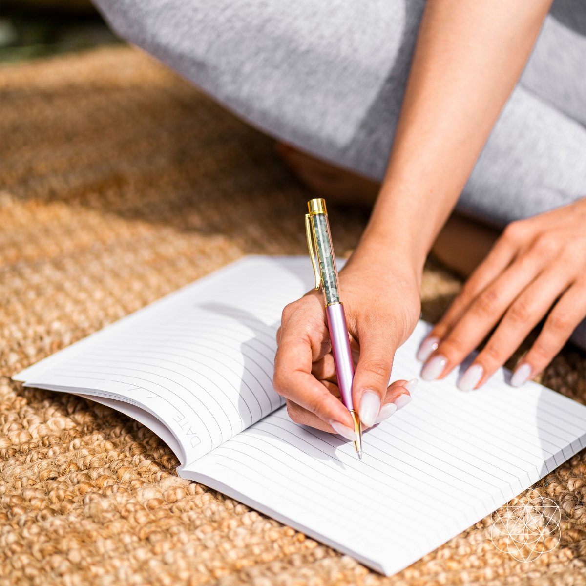 Person writing in a notebook with a pen on a textured surface