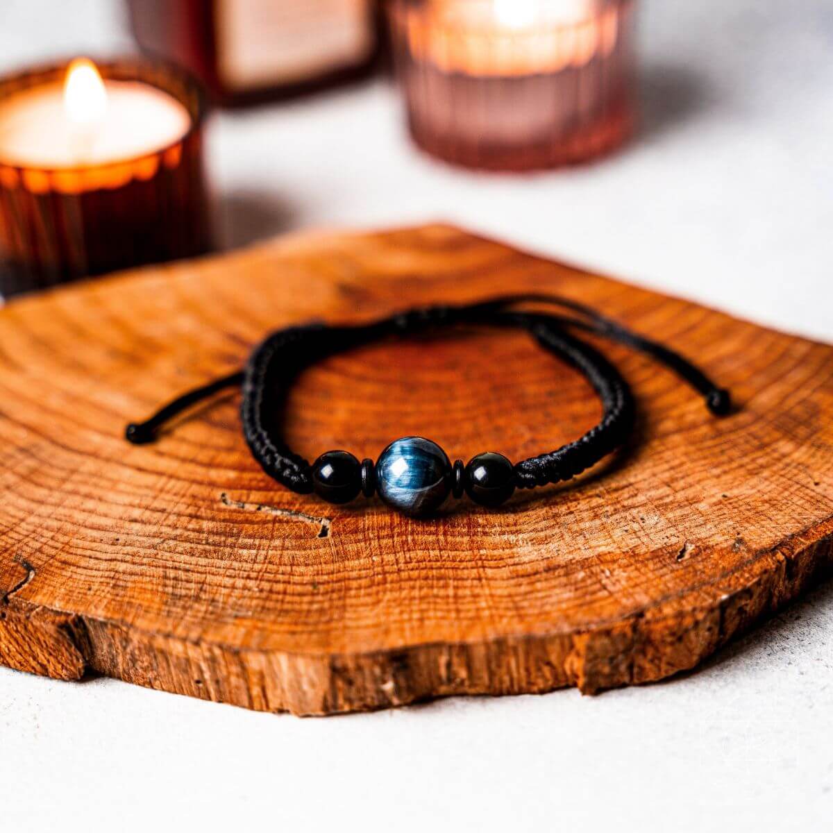 Bracelet with beads on a wooden surface with candles in the background