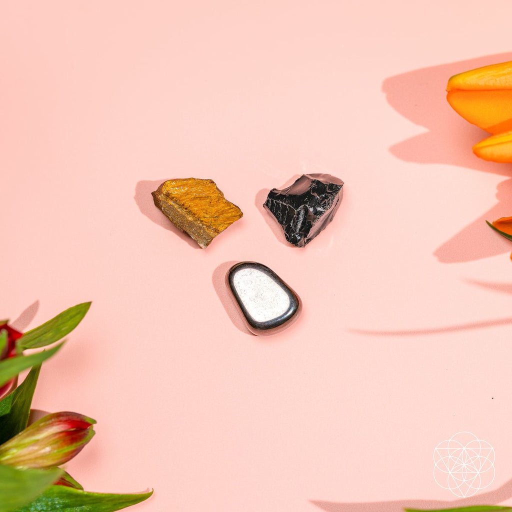 Three stones on a pink surface with floral elements