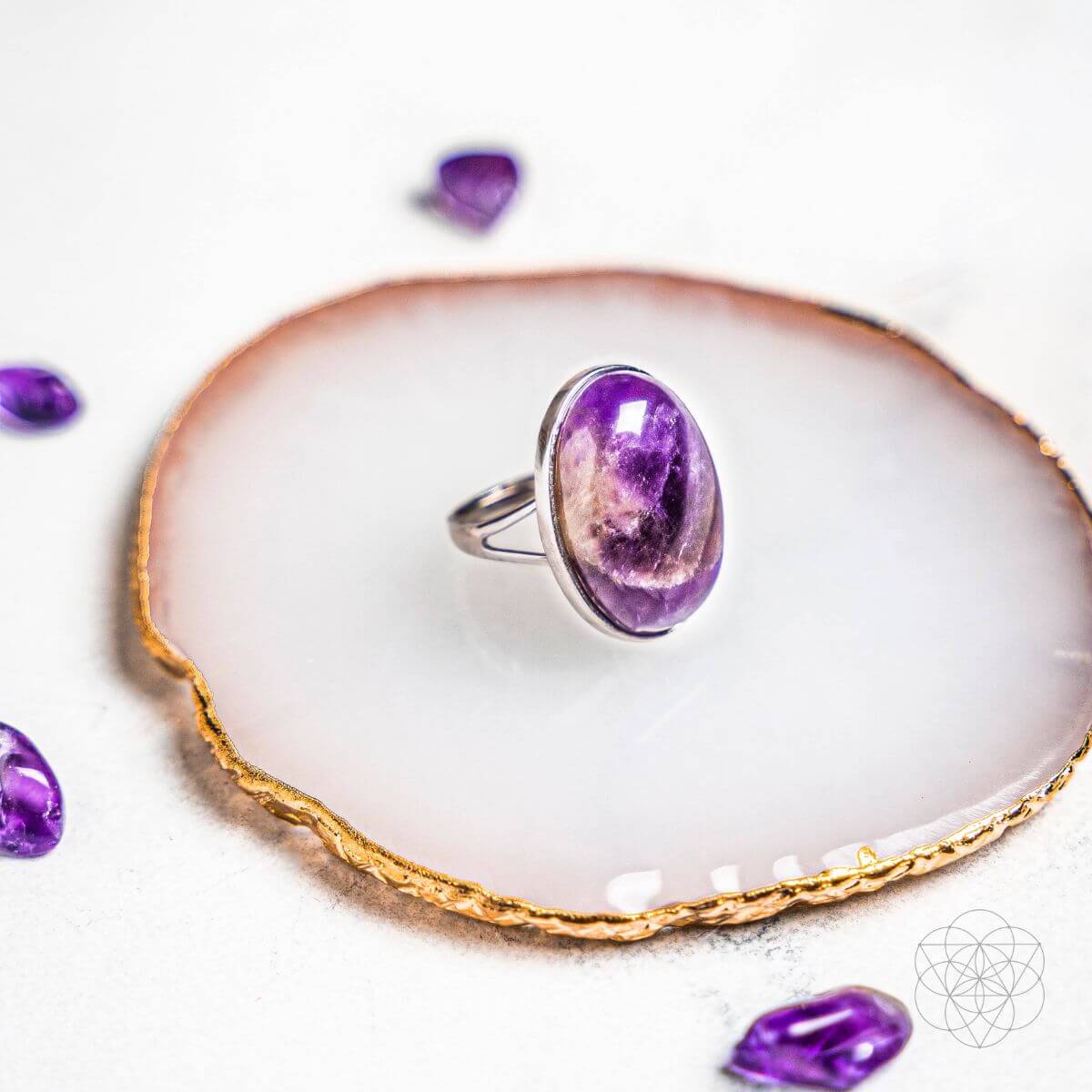 Purple gemstone ring on a white dish with gold rim