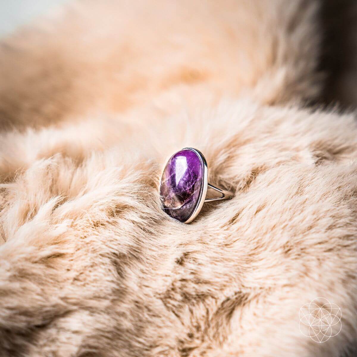 Ring with a purple gemstone on a fur surface
