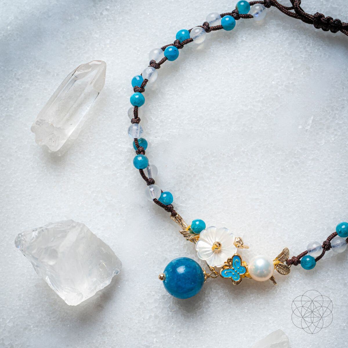 Necklace with blue and white beads on a textured surface with crystals
