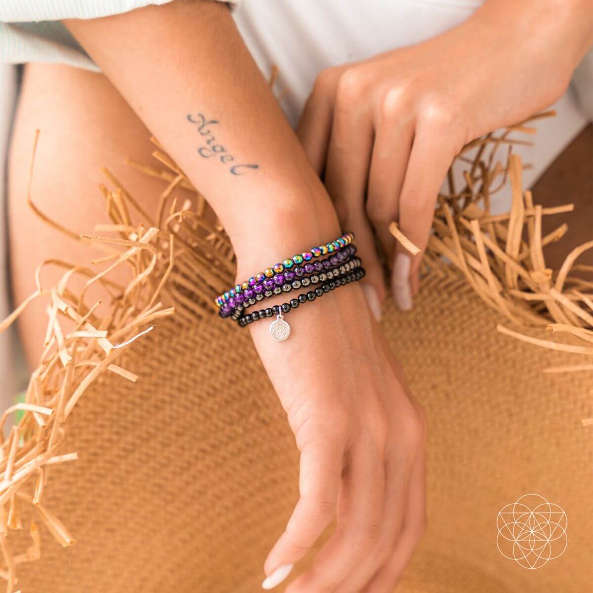Close-up of a wrist wearing colorful beaded bracelets with a neutral background